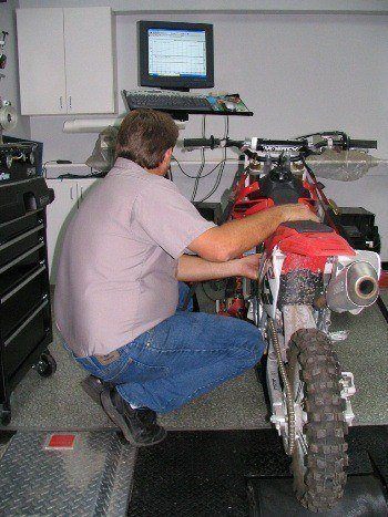 Employee performing service on a motorcycle.